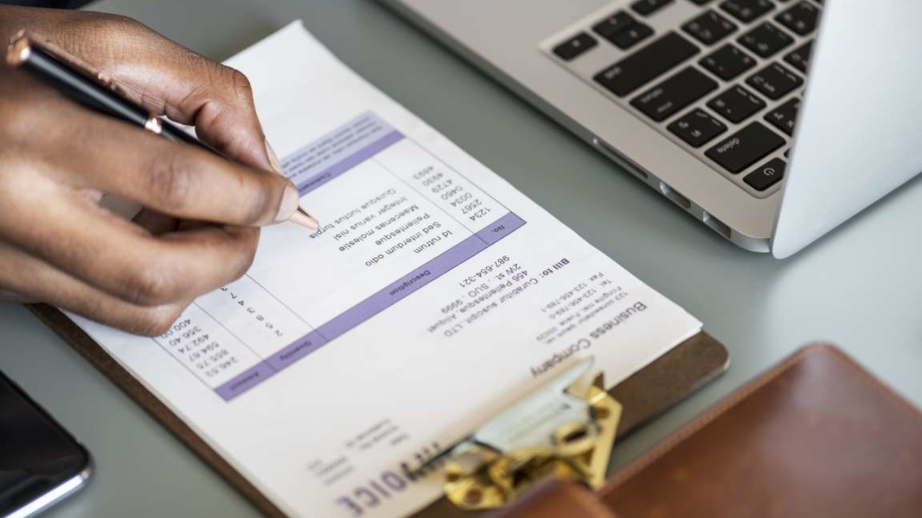 Closeup of business man checking tax invoice paper